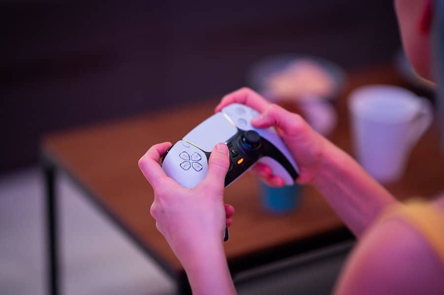女孩在Playstation游戏玩家的手玩视频游戏